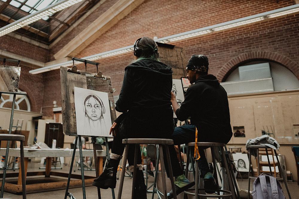 Two students sit together while making self portraits in the Wright Museum's art studio.